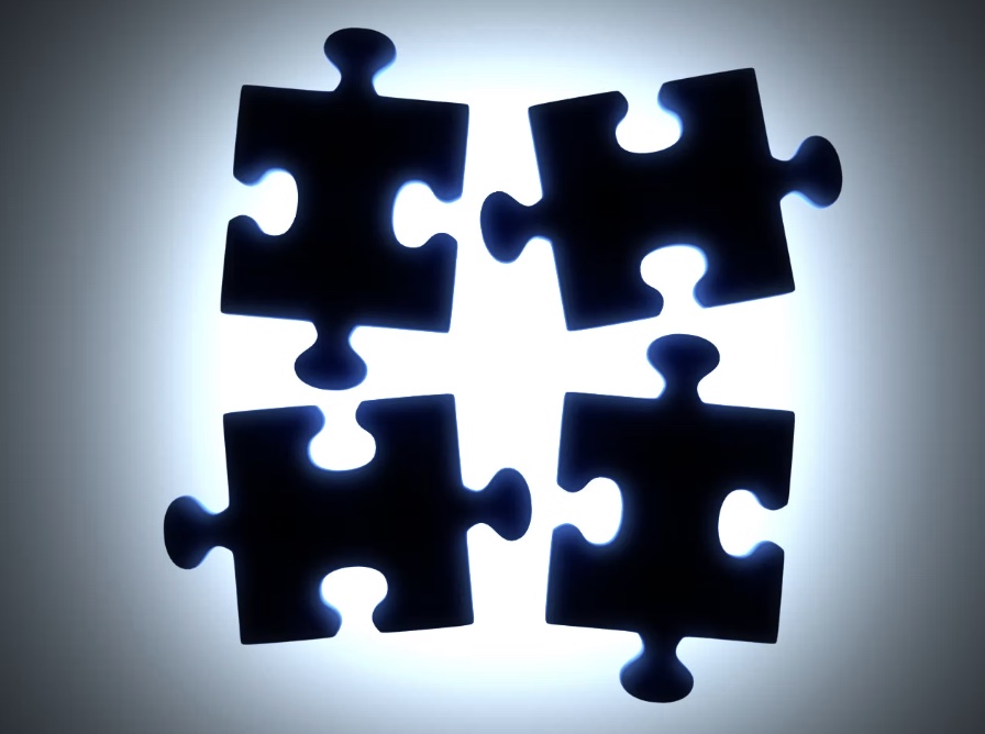 Four jigsaw puzzle pieces, backlit and not yet connected